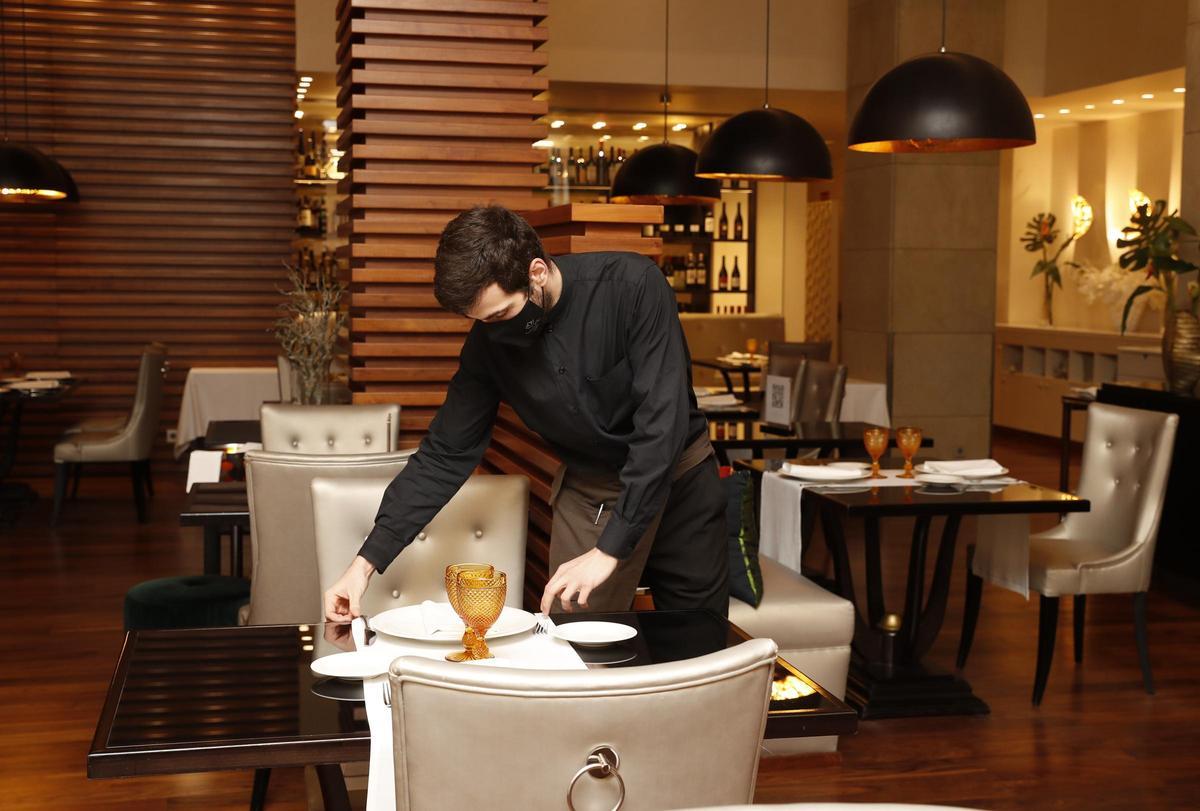 Un camarero del hotel Nagari prepara el comedor del alojamiento.