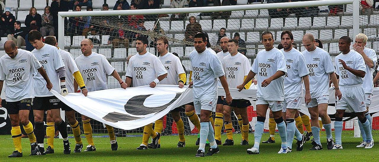 Los jugadores del Celta, con Coudet, y el Alavés, con Abelardo, portan la pancarta el día que Balaídos clamó “Nunca Máis”. |  // CAMESELLE