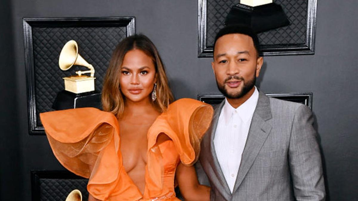 Chrissy Teigen, con vestido naranja de Yanina Couture, y John Legend en los premios Grammy 2020