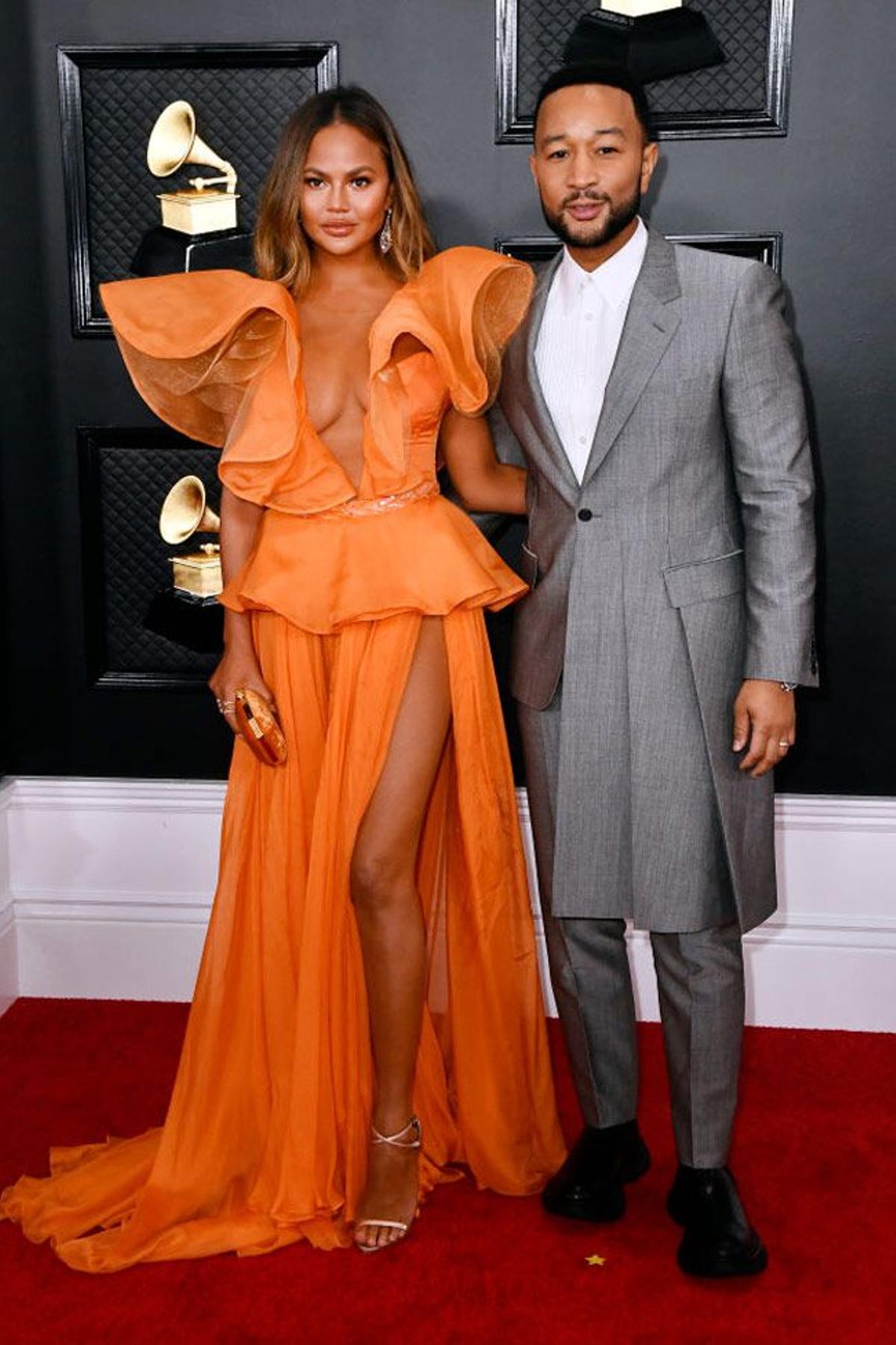 Chrissy Teigen, con vestido naranja de Yanina Couture, y John Legend en los premios Grammy 2020