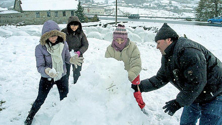 Una familia procedente de A Coruña, ayer, jugando con la nieve en Castro Dozón.