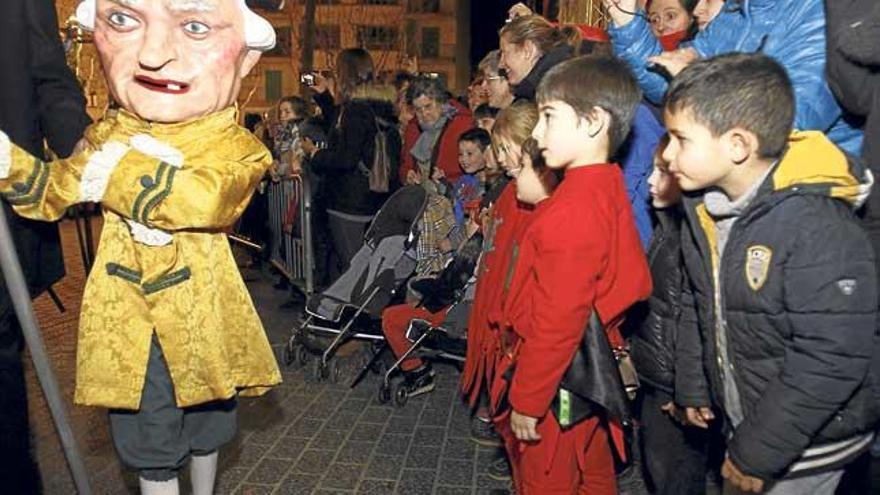 Dos niños observan a uno de los ´caparrots´ que ayer bailaron en la plaza.