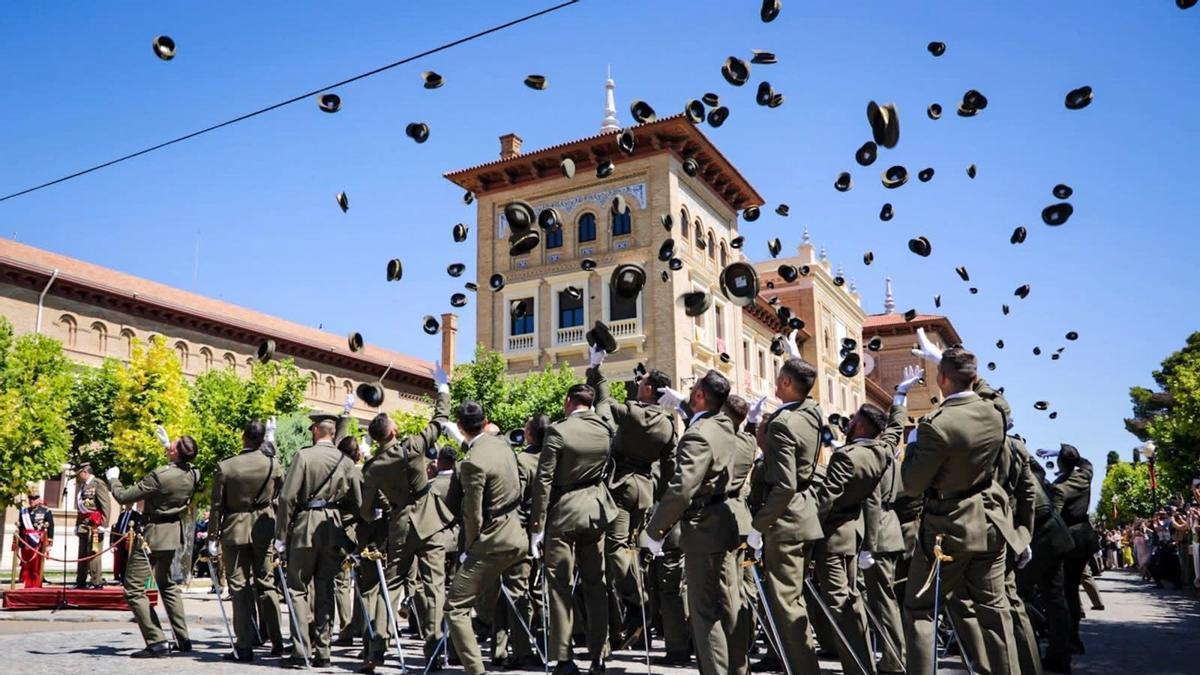Los participantes lanzan las gorras al aire en plena celebración del acto.