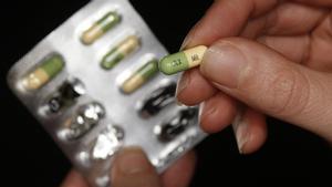 Un paciente muestra una pastilla de un fármaco antidepresivo.