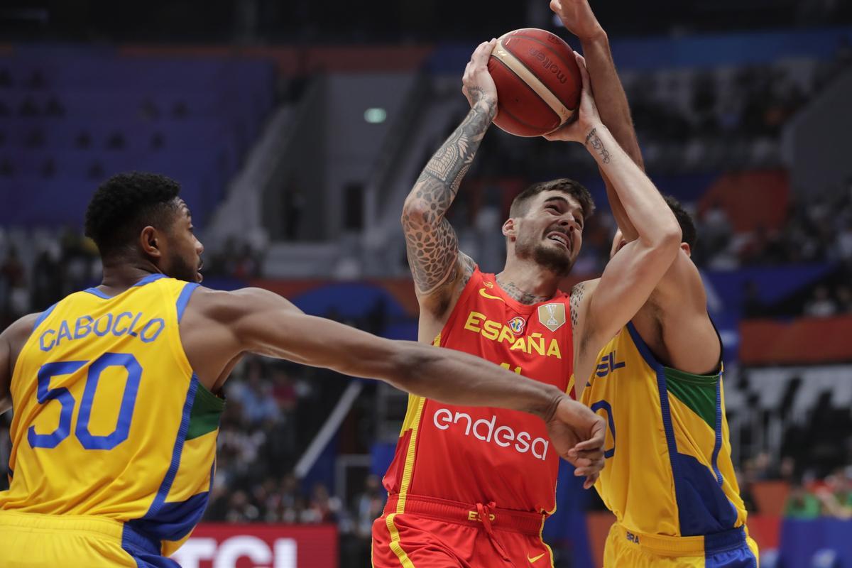 Jakarta (Indonesia), 28/08/2023.- Juancho Hernangomez of Spain (C) in action against Tim Soares of Brazil (R) during the FIBA Basketball World Cup 2023 group stage match between Brazil and Spain in Jakarta, Indonesia, 28 August 2023. (Baloncesto, Brasil, España) EFE/EPA/MAST IRHAM