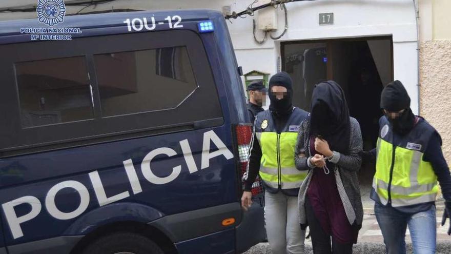 La mujer detenida en Pájara (Fuerteventura) es escoltada por los agentes hasta el furgón policial. // Efe