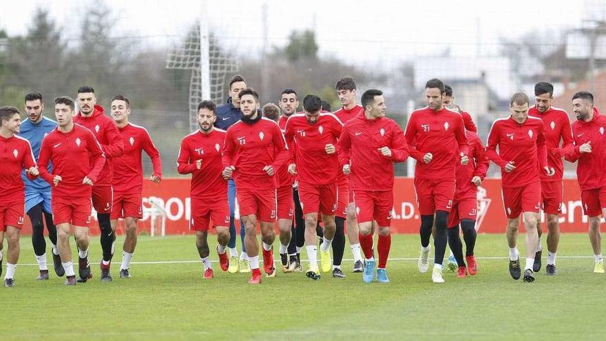 Los jugadores del Sporting realizan ejercicios de calentamiento durante la mañana de ayer en Mareo.