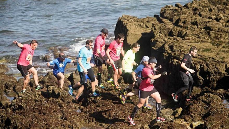 Un grupo de atletas atraviesan una zona de rocas.