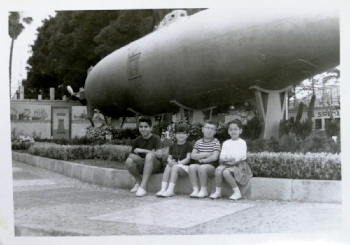 Fotografía de 1966 en la que aparece el historiador cartagenero Diego Quevedo (izquierda), junto a sus primos y su hermana. Al fondo se puede apreciar el submarino Isaac Peral junto al mural cerámico.