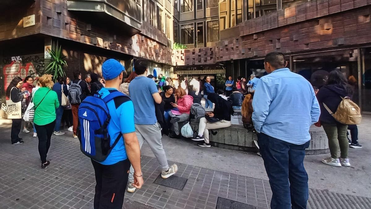 Venezolanos esperan para recibir pasaportes a la entrada del consulado de Venezuela en Barcelona