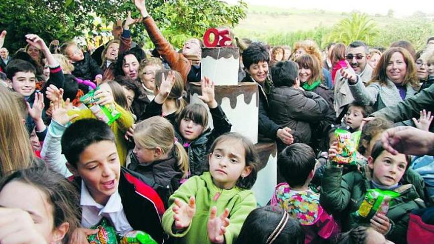 Ex alumnos de la Escuela Infantil San Eutiquio, ayer, en Castiello, junto a la tarta de cartón piedra realizada por el trigésimo aniversario del centro.