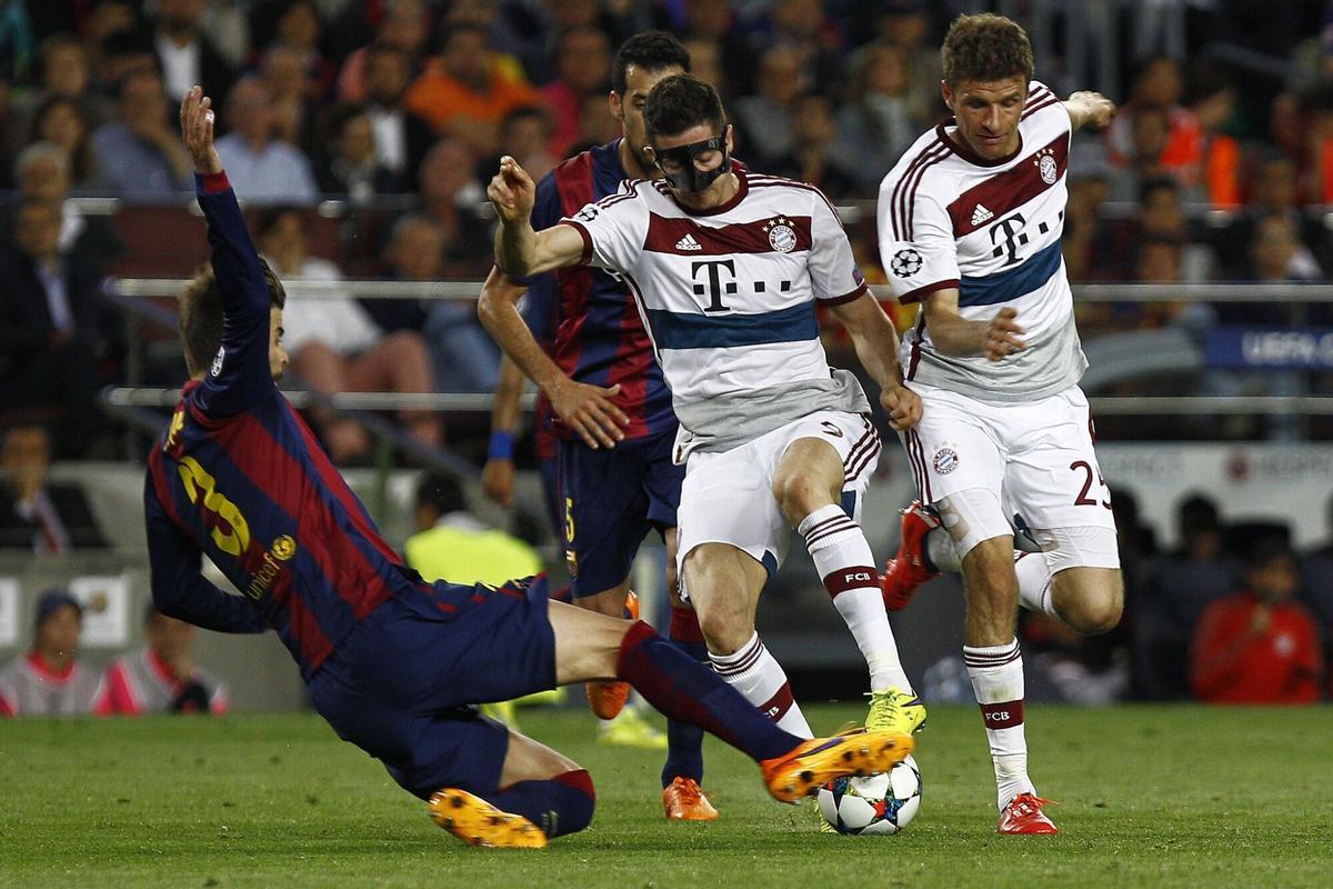 Bayern Munich's Polish forward Robert Lewandowski (C) is tackled by Barcelona's defender Gerard Pique (L) next to Bayern Munich's forward Thomas Mueller during the UEFA Champions League football match FC Barcelona vs FC Bayern Muenchen at the Camp Nou stadium in Barcelona on May 6, 2015.     AFP PHOTO/ QUIQUE GARCIA. horizontal