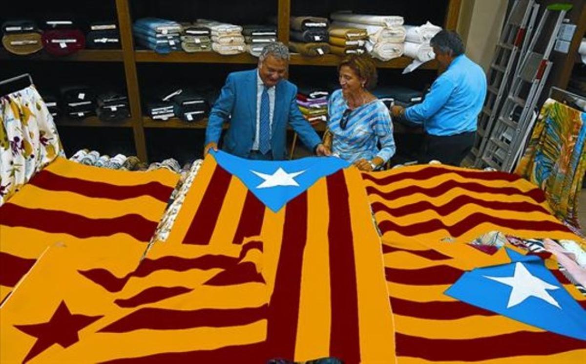 Josep Muniesa, encarregat de la botiga de teles Ribes i Casals de Barcelona, sosté algunes estelades a la venda al local. Josep Muniesa, encarregat de la botiga de teles Ribes i Casals de Barcelona, sosté algunes estelades a la venda al local.