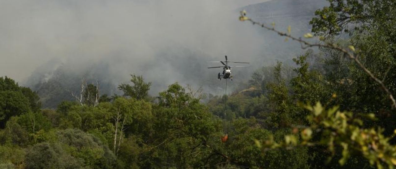 Un helicóptero trabaja en la extinción del incendio de O Barco de Valdeorras. | // ROSA VEIGA