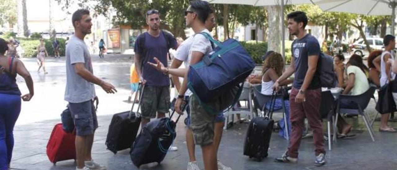 Turistas cargados con maletas en la Plaza de España de Palma