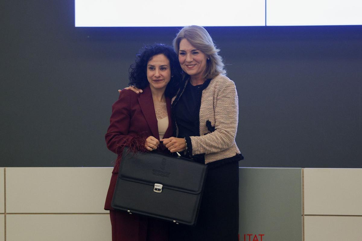 La consellera de Servicios Sociales, Familia e Infancia, Elena Albalat recibe la cartera de manos de su predecesora, Susana Camarero, durante el acto de cambio de carteras celebrado en la tarde de este jueves. EFE/Manuel Bruque