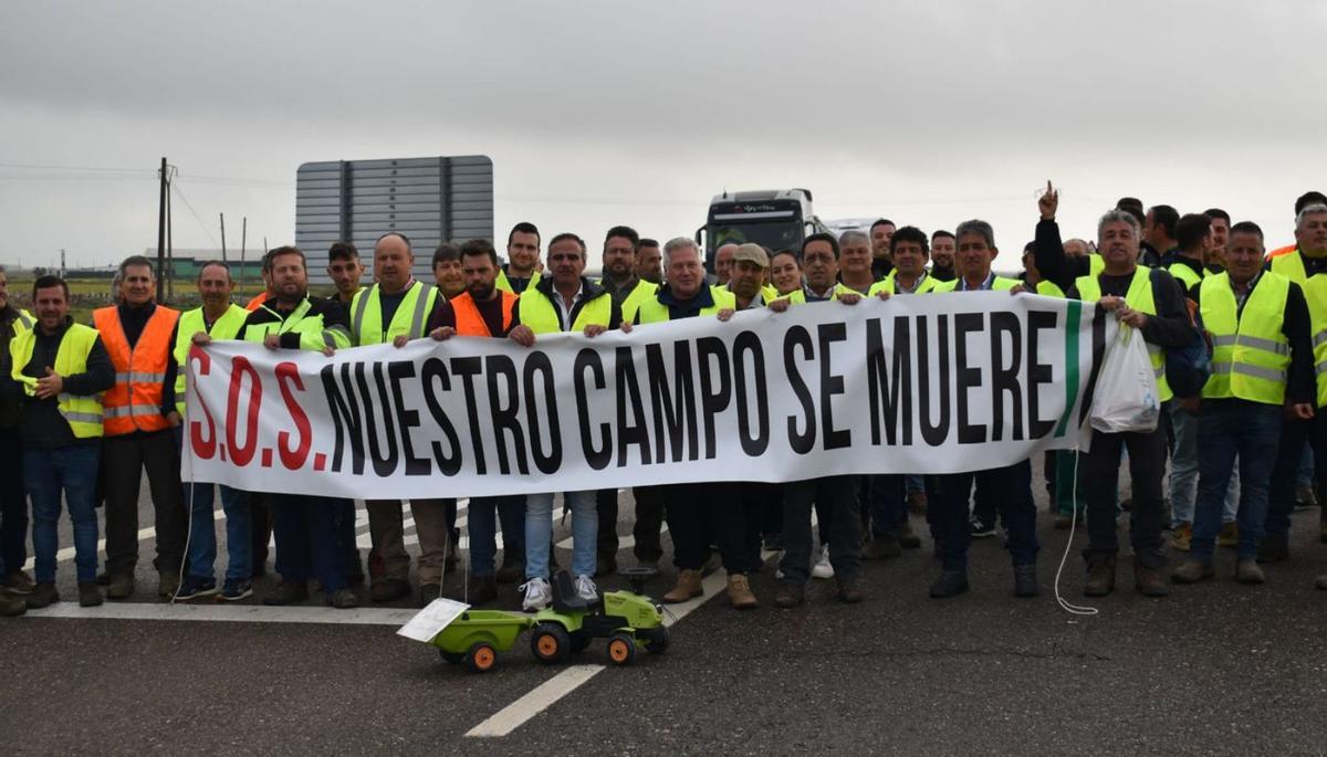 Los manifestantes en Santa Amalia con una pancarta reivindicativa. | SAMUEL SÁNCHEZ
