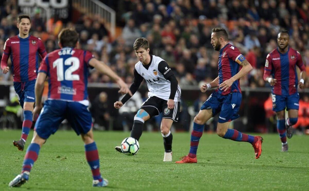 Luciano Vietto conduciendo un balón rodeado de granotas