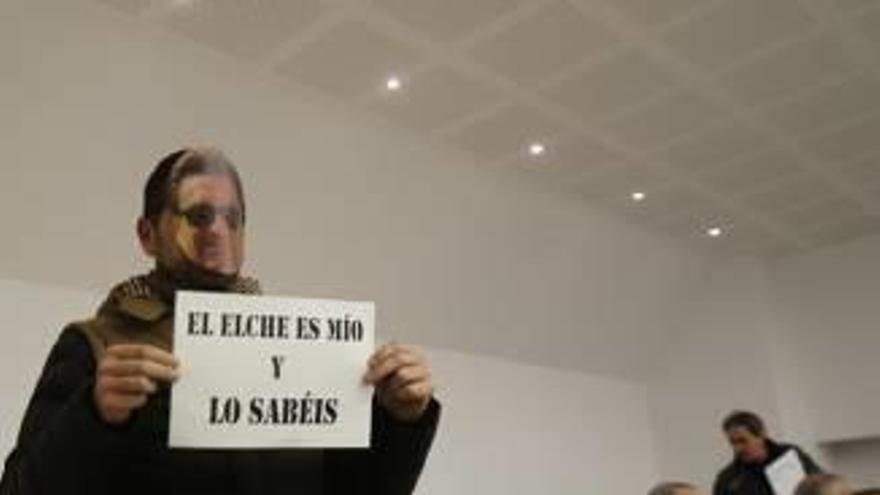 Un accionista acude a la junta con una careta de José Sepulcre y un cartel.