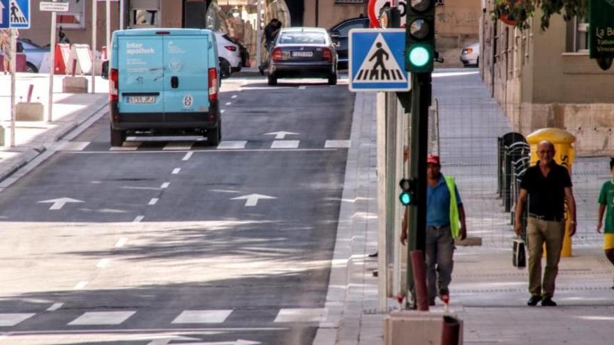 Imagen de los primeros vehículos circulando por el primer tramo abierto de la calle Entenza tras las obras de remodelación.