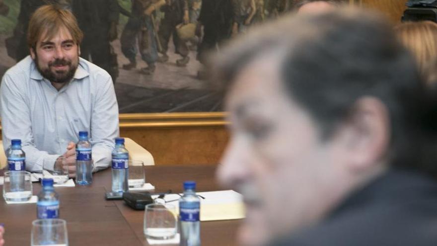 El secretario general de Podemos, Daniel Ripa, al fondo, y el presidente del Principado, Javier Fernández, durante su reunión para negociar el presupuesto de 2019.