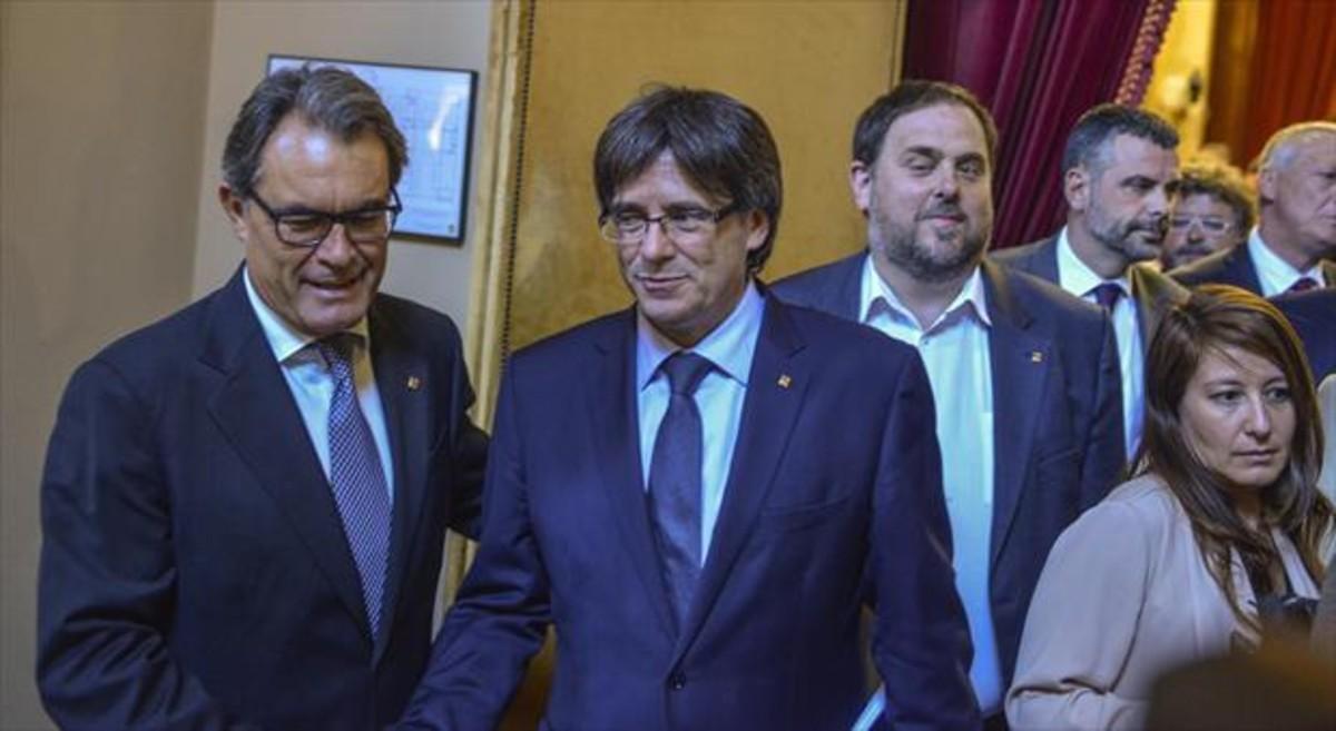 Mas saluda a Puigdemont ante la mirada de Junqueras, ayer en el Parlament.