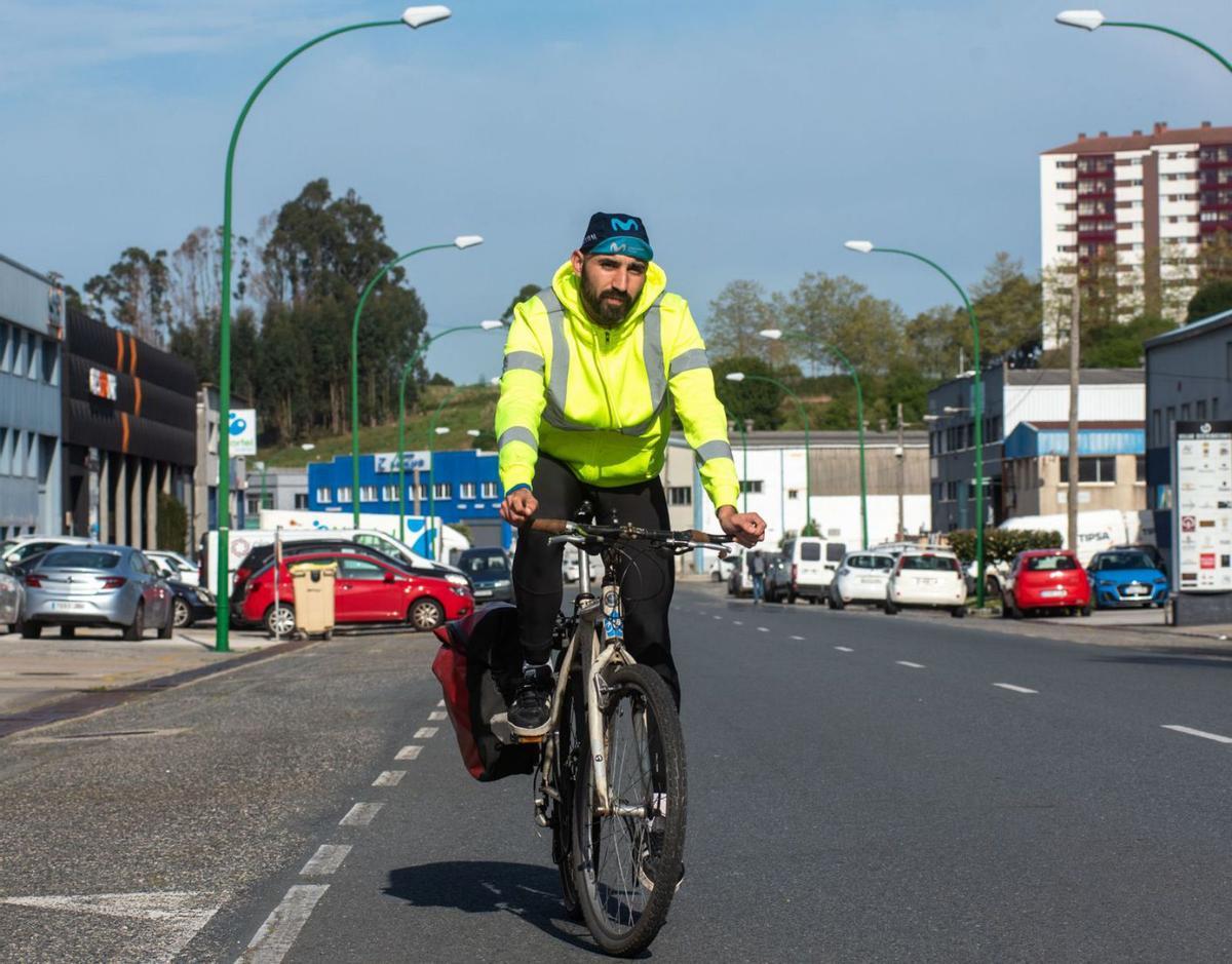 Álex Voces, sobre su bicicleta al salir de su trabajo en el polígono de Pocomaco.   | // CASTELEIRO/ROLLER AGENCIA