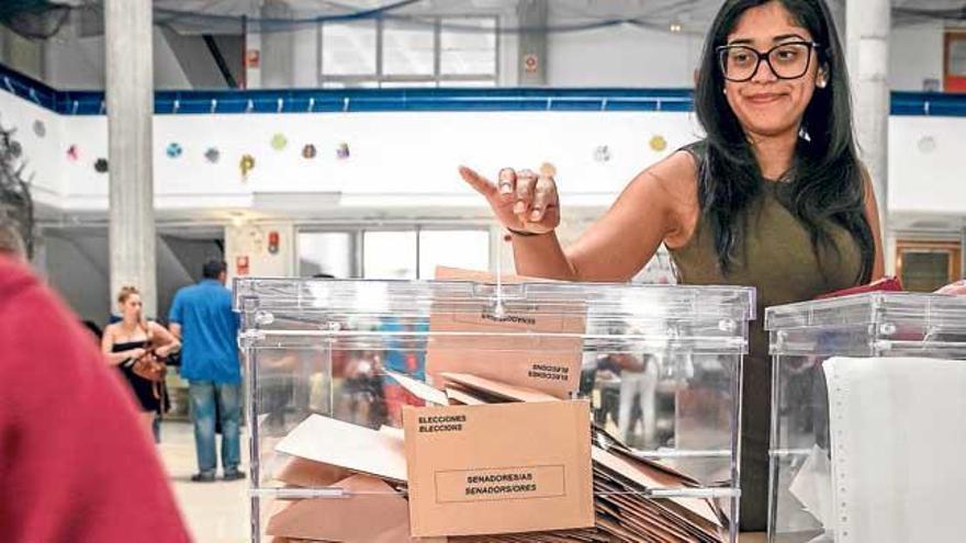 Una joven deposita su voto para el Senado en el colegio de Son Canals.