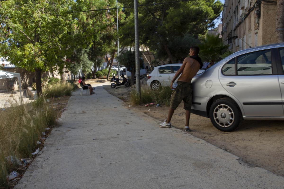 Un hombre junto a un coche en la calle Poeta Vicente Medina del barrio Juan XXIII de Alicante, en una imagen de archivo.