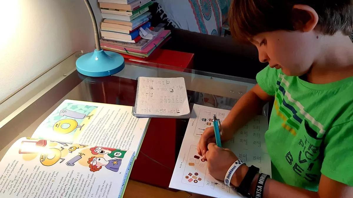 Un xiquet de Primària, fent activitats de Matemàtiques a casa.