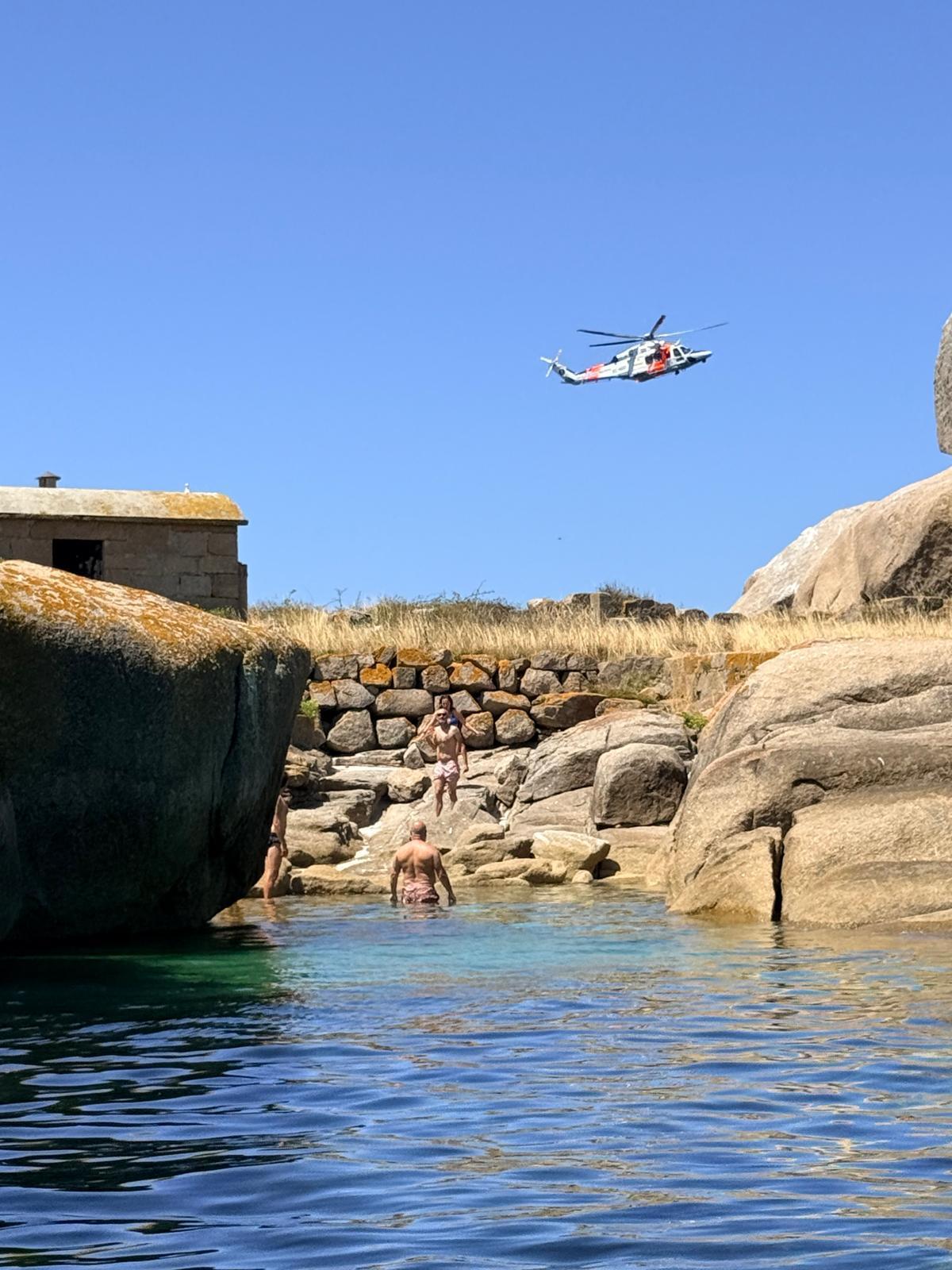 Los bañistas observan las maniobras de la aeronave.