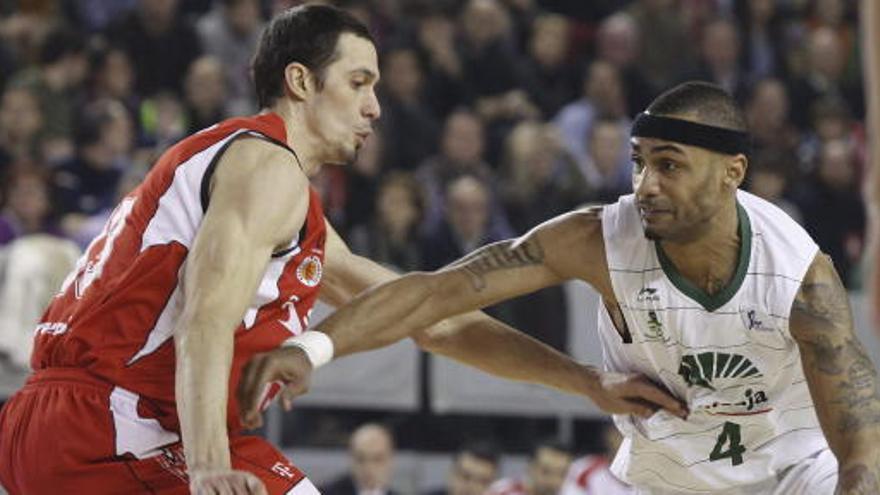 El escolta estadounidense del Unicaja Gerald Fitch (d) bota el balón ante el alero ucraniano del Assignia Manresa Sergiy Gladyr.