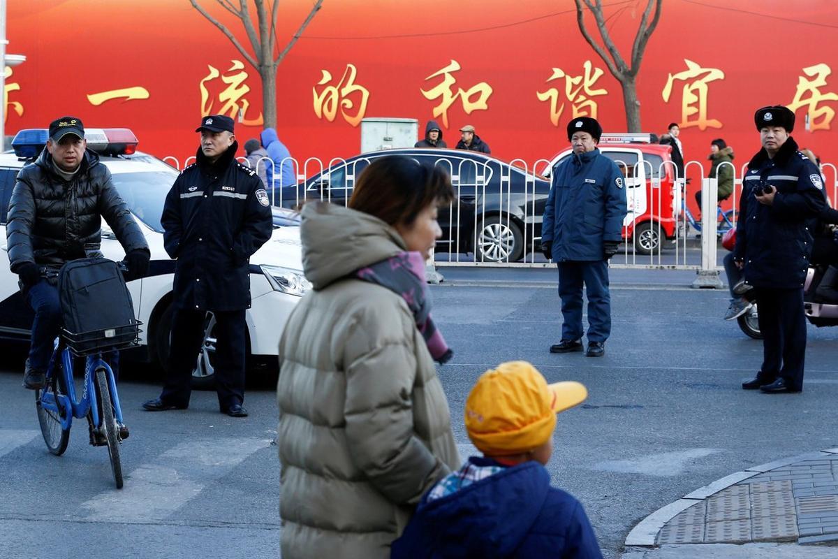 REFILE - CORRECTING TYPE OF ATTACK  Police watch as a woman and a child leave a primary school that was the scene of a hammer attack in Beijing  China  January 8  2019   REUTERS Thomas Peter