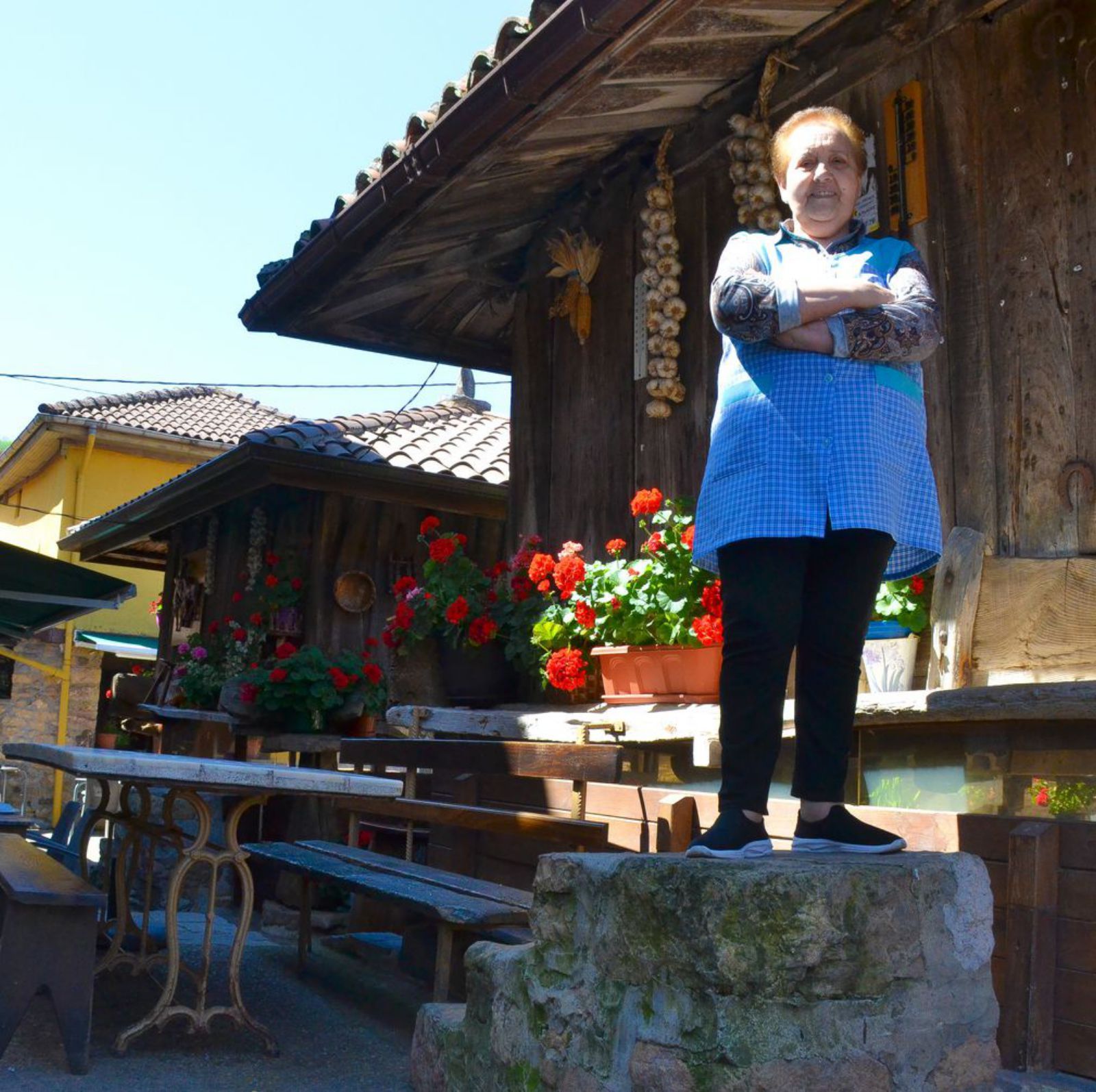 Enedina García, propietaria de Casa Generosa, en Pedroveya (Quirós), posa en la subidoria de uno de sus hórreos.