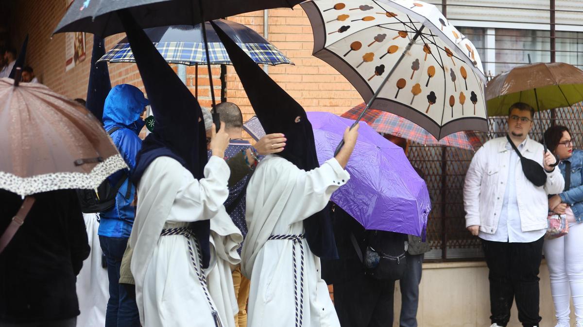 Nazarenos se protegen de la lluvia.