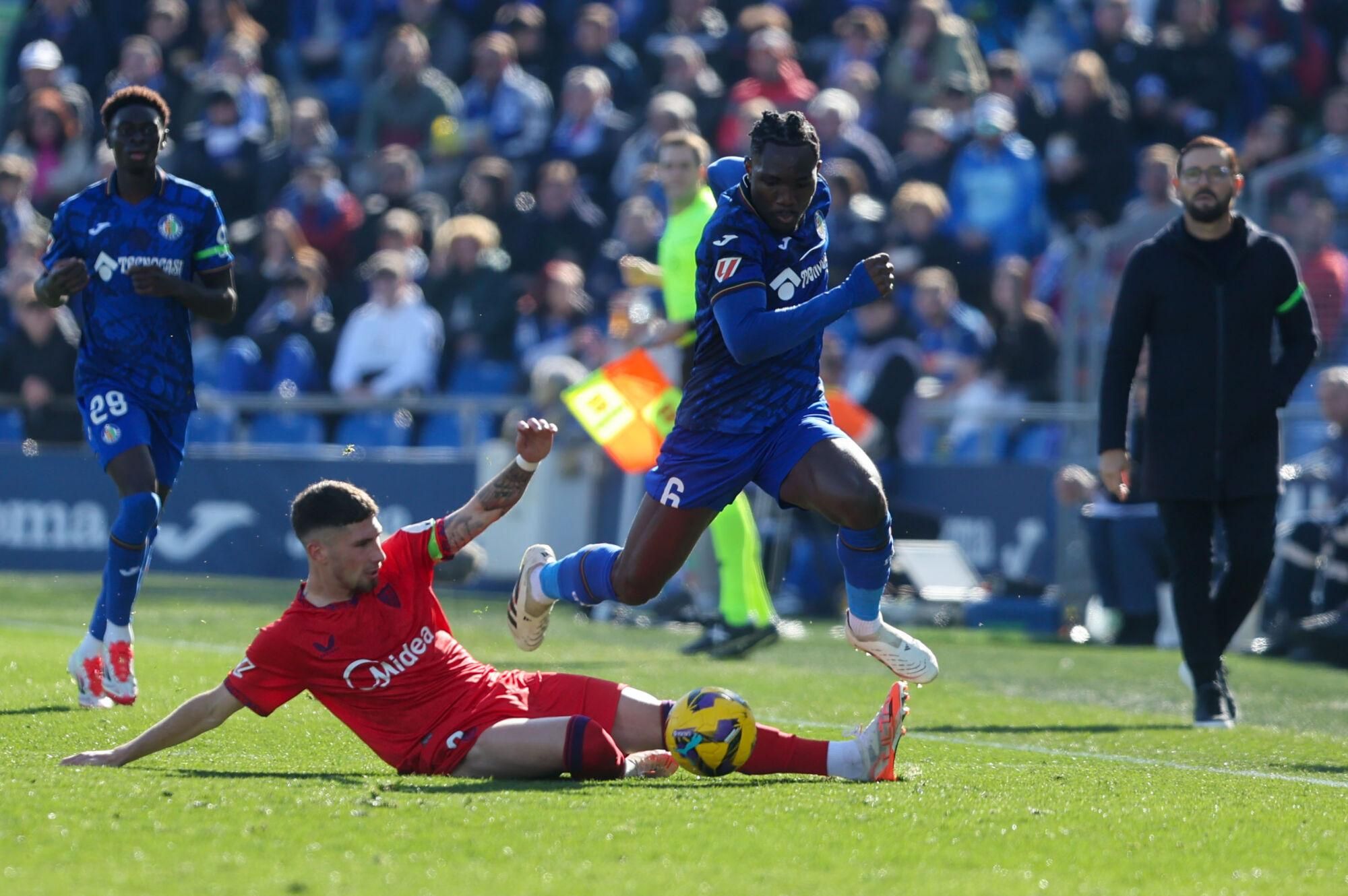 El defensa del Sevilla Carmona (i) lucha por el balón con el centrocampista Christian Uche (d) del Getafe durante el partido de LaLiga que enfrenta al Getafe contra el Sevilla en el Coliseum en Getafe. EFE/ Kiko Huesca. (GETAFE) (SEVILLA)