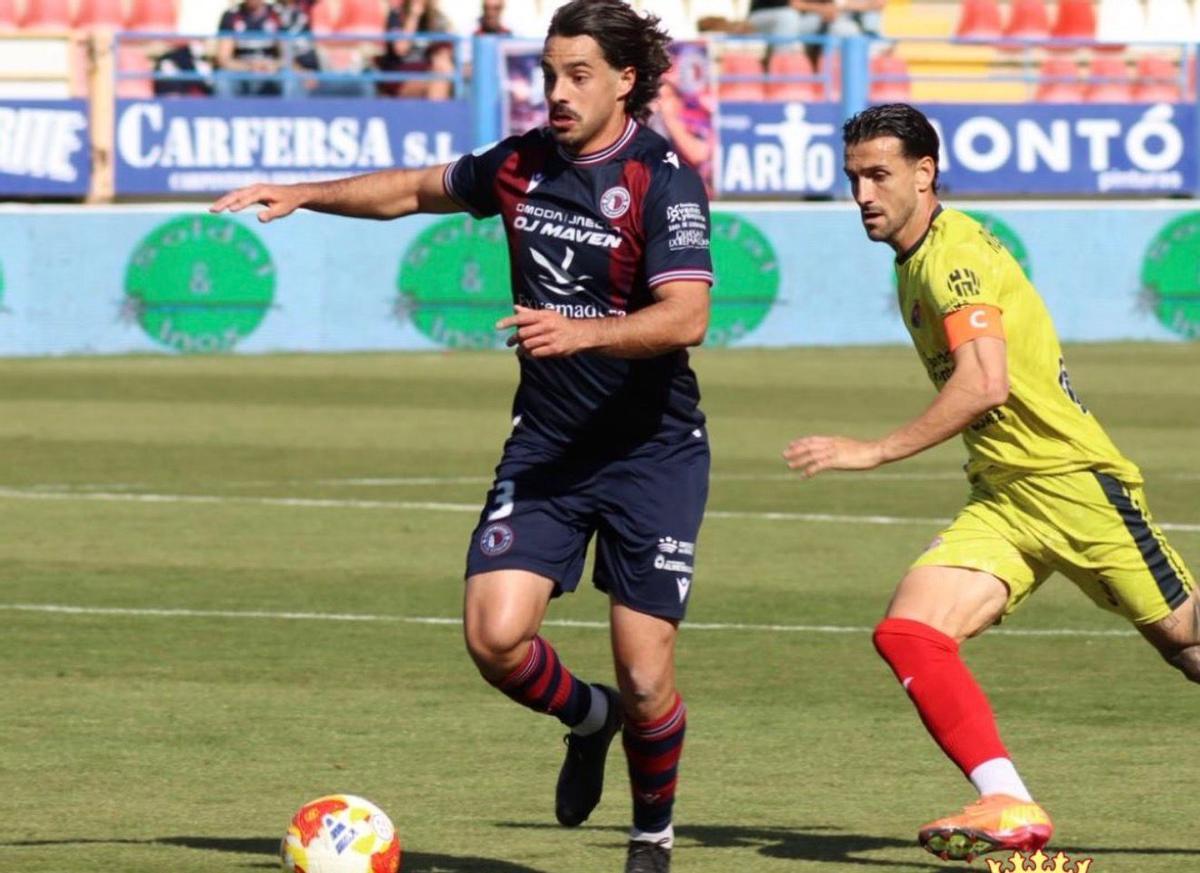 Carlos Cordero, del Extremadura, perseguido por Rubén Mesa, de la Minera