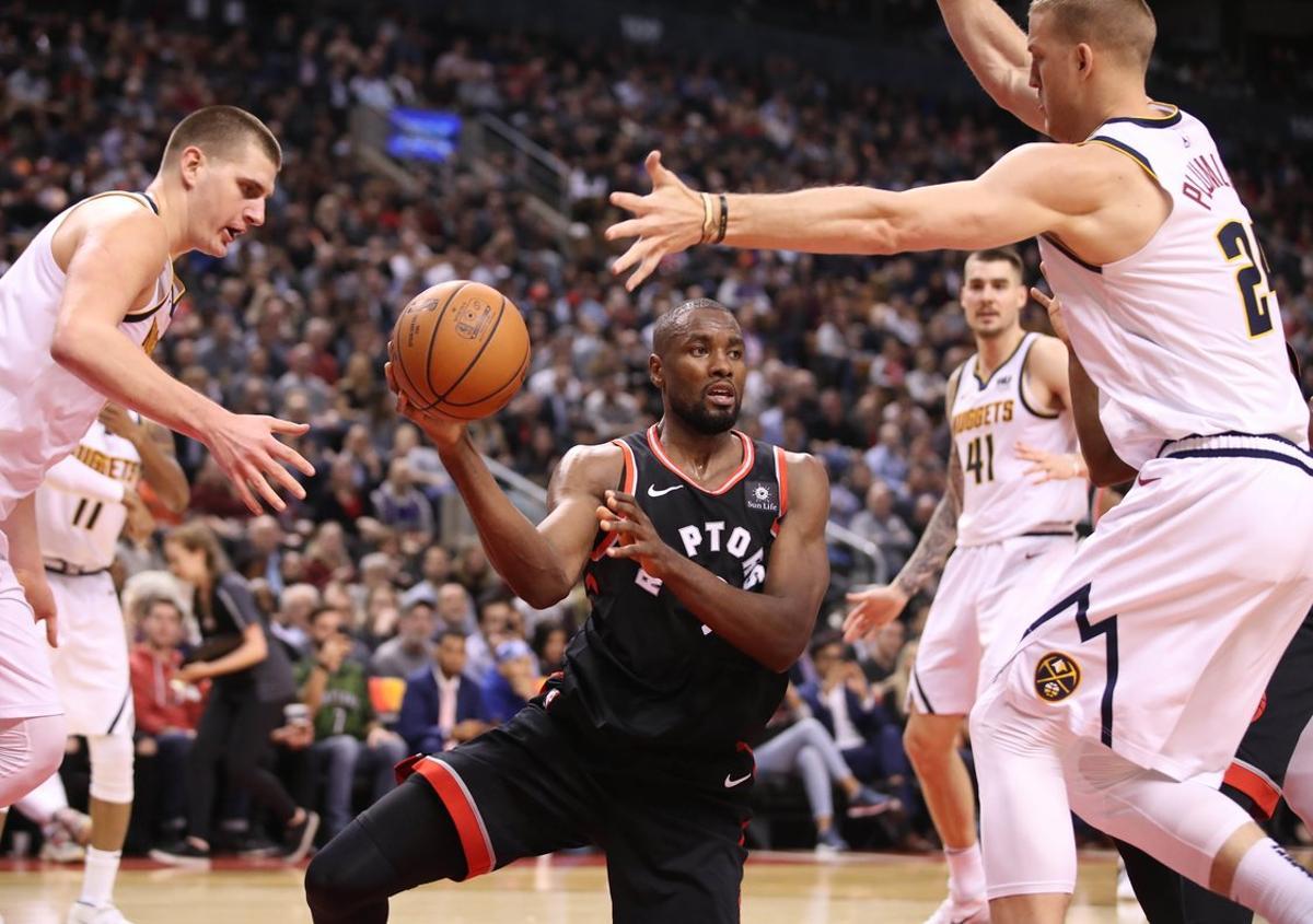 Dec 3, 2018; Toronto, Ontario, CAN; Toronto Raptors forward Serge Ibaka (9) looks to pass as he is guarded by Denver Nuggets forward Mason Plumlee (24) in the third quarter at Scotiabank Arena. The Nuggets beat the Raptors 106-103. Mandatory Credit: Tom Szczerbowski-USA TODAY Sports