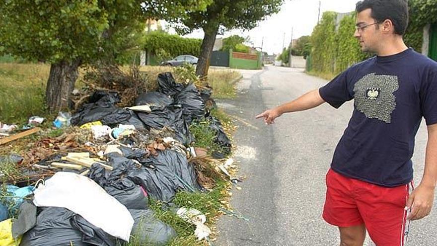 Un vecino de la calle Area Alta, en Panxón, muestra la basura acumulada cerca de las viviendas.