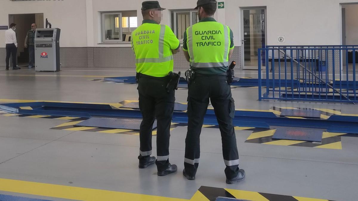 Dos agentes vigilan
las instalaciones de
la ITV de San Javier
durante las detenciones.  G.C.