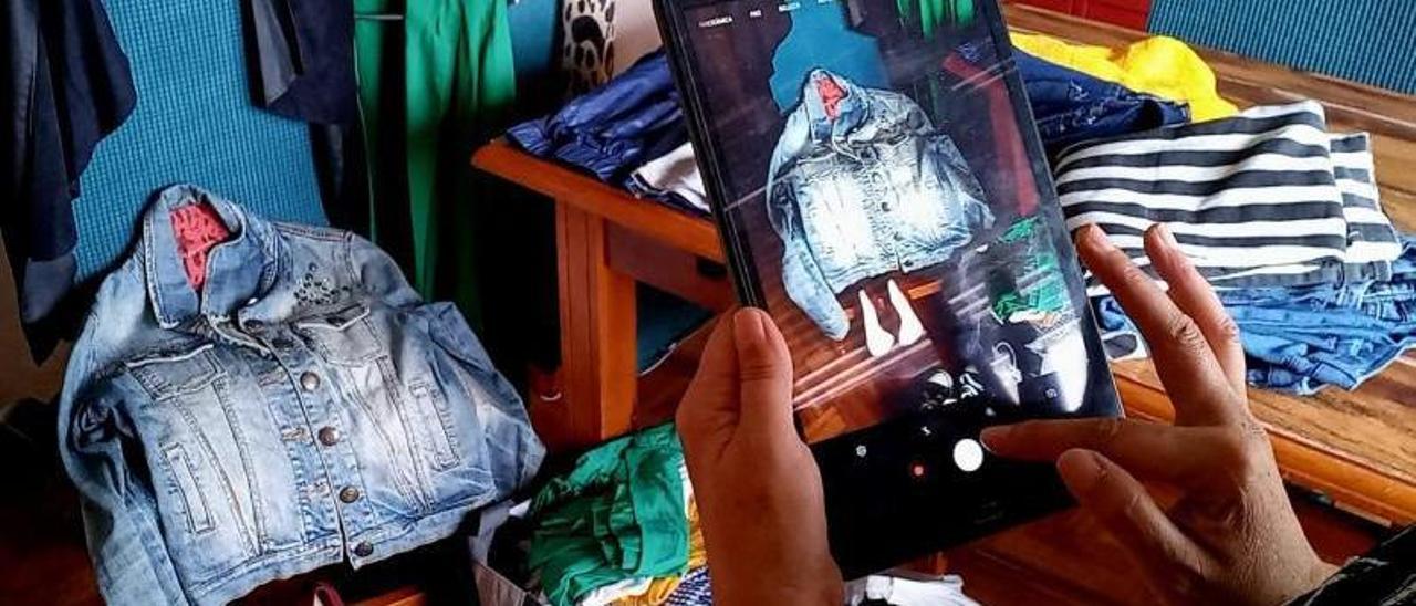 Una vendedora de ropa por internet fotografía una de sus prendas.