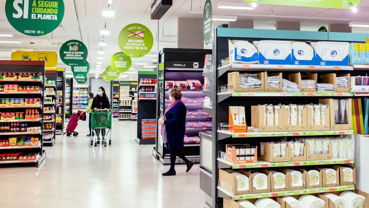 Un supermercat de Mercadona amb clientes comprant i cartells sobre sostenibilitat el desembre del 2021