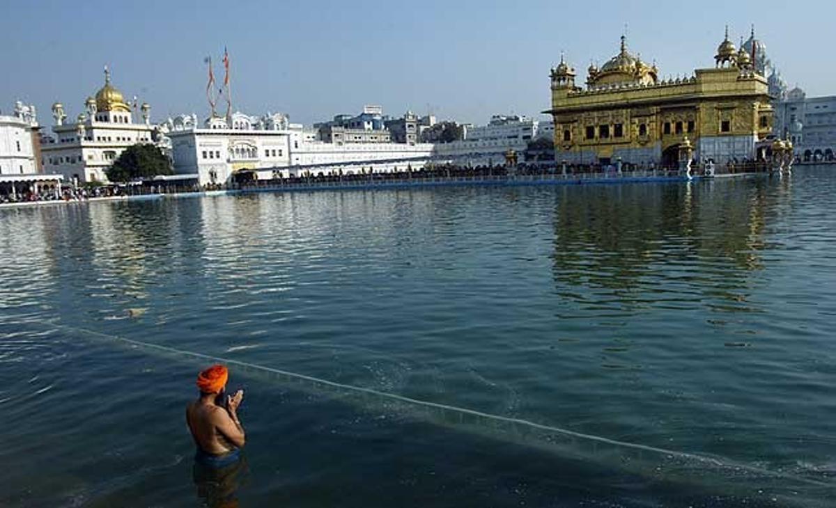 Un devot fa un bany ritual al temple Daurat, el més sagrat dels santuaris sikh, en ocasió de la celebració del festival Visakhi, a Amrítsar (Índia).