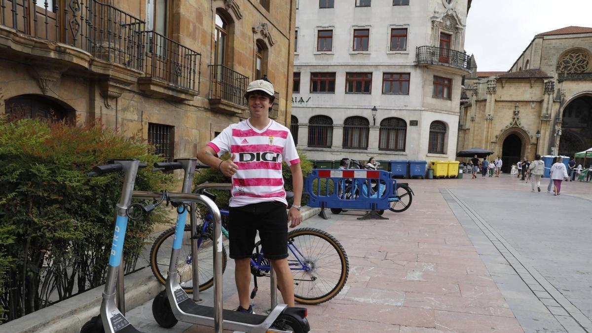 Andrés García posa junto a los patinetes de alquiler en la plaza de la Catedral.