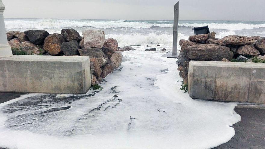 El agua penetra en el paseo marítimo en la playa de La mezquitilla.