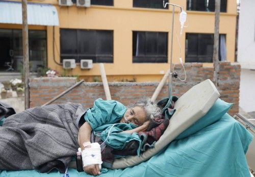 Una mujer anciana recibe tratamiento médico a las afueras del hospital en Katmandú