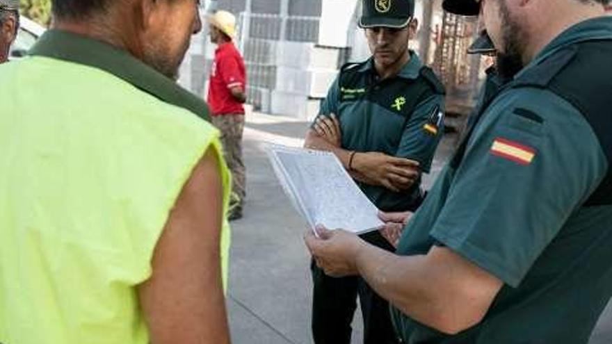 Efectivos de la Guardia Civil analizan las rutas ante un vecino.