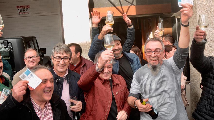 Agraciados festejan el premio ante el bar Alborada de Moraña. // Rafa Vázquez