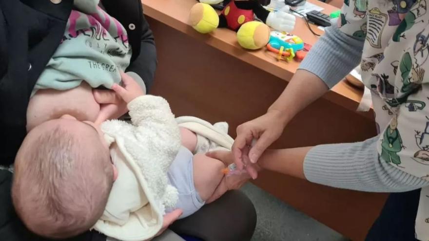 Una enfermera administra una vacuna a un bebé. |  // EPC