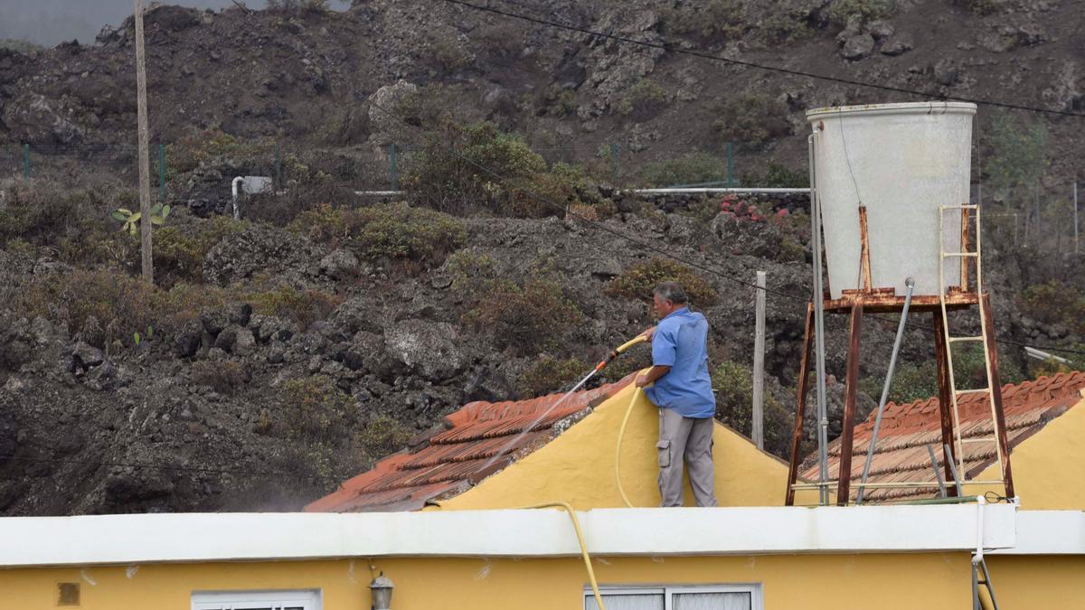 Los vecinos retiran la ceniza que ha cubierto toda La Palma